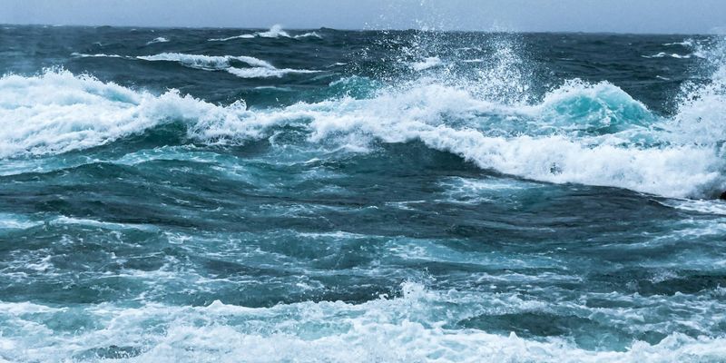 Olas rompiendo en la orilla bajo un cielo gris